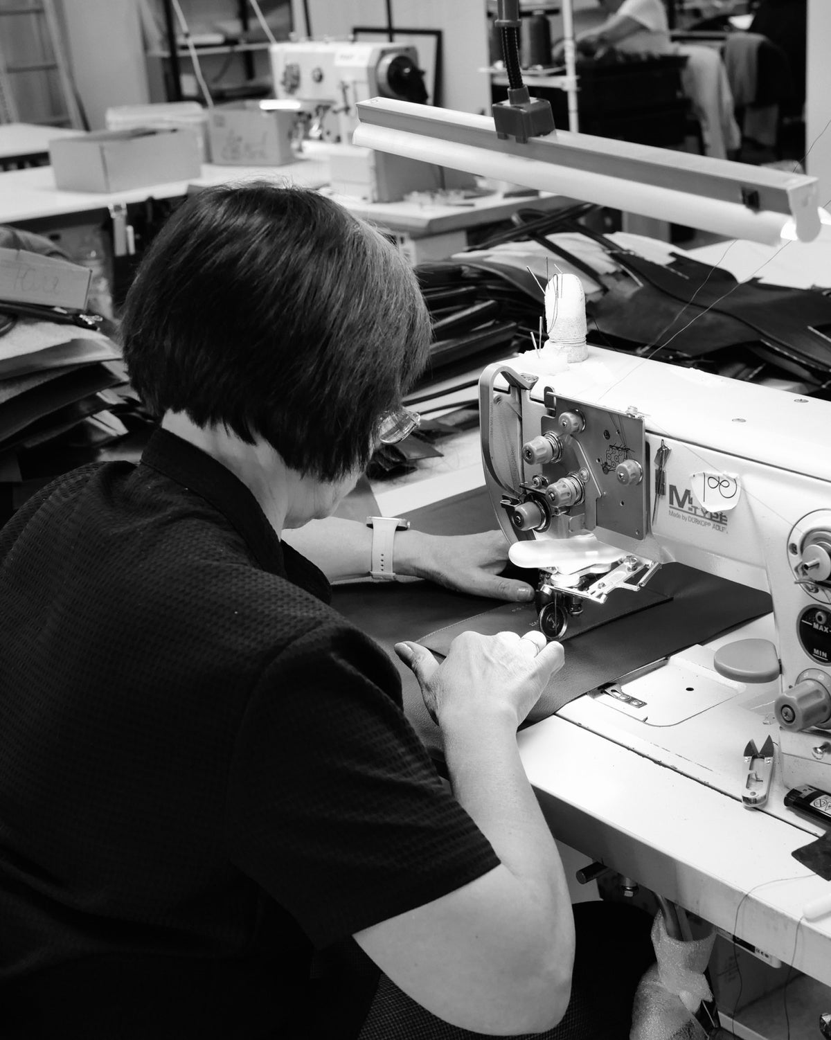 Krawcowa przy maszynie do szycia w atelier Poelle